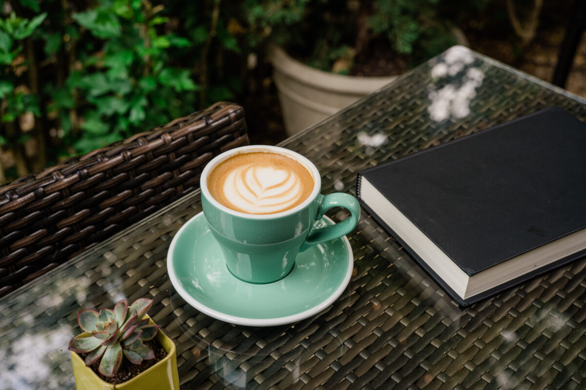 coffee, book, and plant at Behind the Bookstore